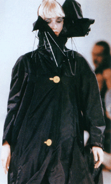 Raincoat with broken collapsible umbrella as high collar by John Galliano
