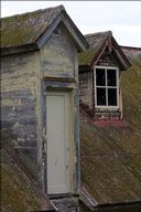Weathered roof of building on hill stretching from dock to Alcatraz prison